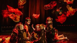 dzieci na scenie, podrzucają do góry chusty - jesienne liście