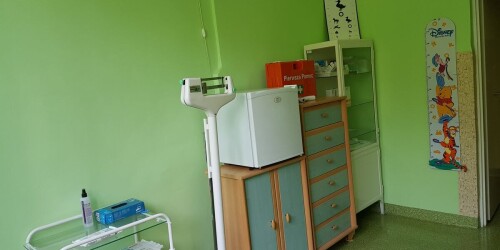 wnętrze gabinetu pielęgniarki z szafkami, lodówką na leki i wagą