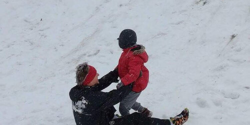 chłopiec bawi się z nauczycielem na śniegu