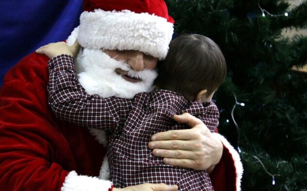 Chłopiec przytula się do świętego Mikołaja