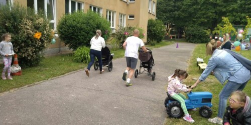 wyścigi - rodzic i nauczyciel biegną z dziećmi w wózkach biegowych