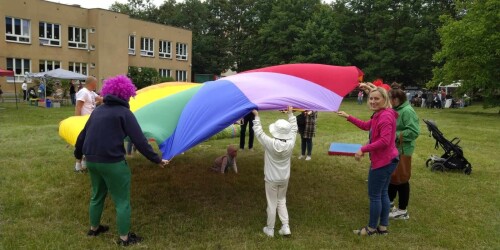 dzieci i nauczyciele bawią się kolorową chustą animacyjną